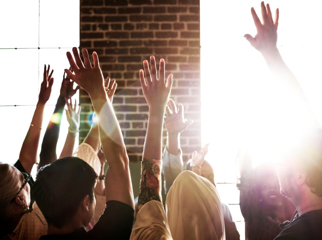 People raising their hands in a seminar